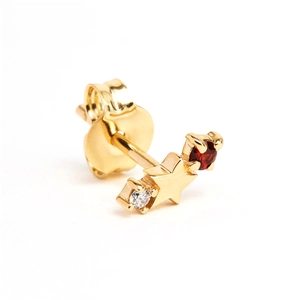 Macro view of gold star stud earring with inlaid red and clear gemstones on white background