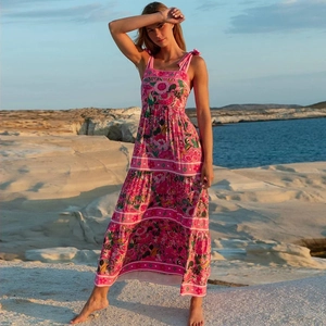 Détail de la robe longue rose à fleurs avec jupe à volants et bretelles à nouer