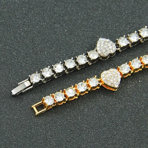 Detail of hip-hop iced-out Cuban bracelets in gold and silver with heart charms
