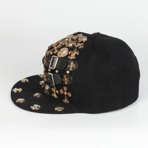 Detail of hip hop hat with golden cross studs and black leather belt buckles on brim