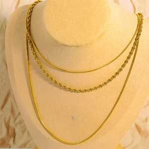 Detailed view of triple-layered gold titanium steel necklaces on a professional bust