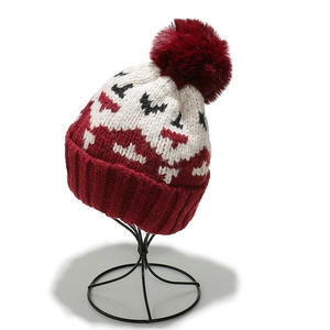 Detail of winter knit beanie with mohair texture, geometric patterns, and red pom-pom