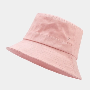 Close-up of pink cotton bucket hat showing twill texture and metal ventilation eyelets