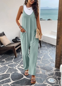 Détail d'une combinaison vert menthe à col en V, jambes larges et poches en décor de plage