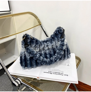 Detail of plush faux fur handbag with blue grey gradient texture on a modern chair