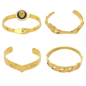 Lion head medallion and textured gold bangles in a four-piece stackable jewelry set