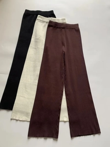 Dettaglio dei pantaloni in maglia a coste in nero, panna e caffè con elastico in vita