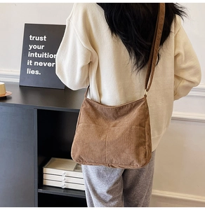Brown corduroy crossbody bag texture detail shown with external pocket on model