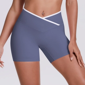 Detail of cross-waist design on high-rise yoga shorts with white trim and v-cut styling