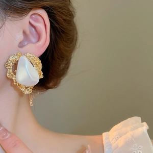 Détail d'une boucle d'oreille triangle en perle vintage sur modèle avec métal martelé