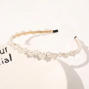 Macro detail of elegant pearl headband with gold alloy base and tiered white beads
