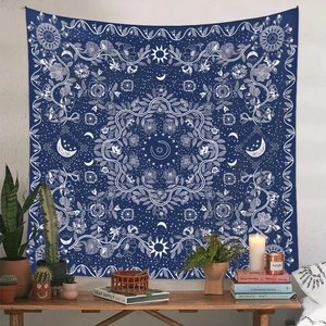 Detail eines böhmischen Wandteppichs mit Sonne und Mond über einem Holztisch mit Deko