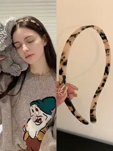 Detail of leopard print headband showing thin acrylic frame and retro tortoise pattern