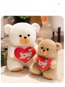 Close-up of fluffy teddy bears in white and brown holding red plush hearts with Love embroidery