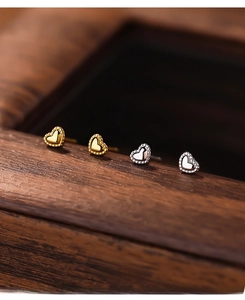 Macro shot of S999 silver heart earrings in gold and silver with beaded edges