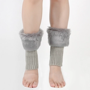Detail of grey faux fur trim and ribbed knit texture on winter leg warmer boots