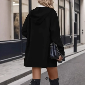 Vista dettagliata della giacca nera oversize con cappuccio e accessorio a catena