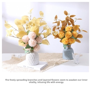 Detail of pink and yellow pompon mums in textured ceramic vases on a lace tablecloth