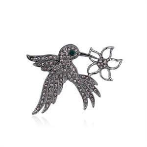 Detailed close-up of a vintage hummingbird brooch with pink rhinestones and flower