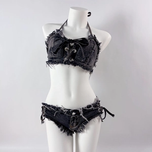 Dettaglio completo di set in denim grigio scuro con top stringato e pantaloncini con frange
