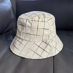 Detailed texture of linen-blend plaid bucket hat with minimalist checkered pattern