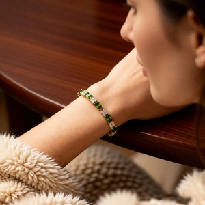Detailed macro view of 18k gold plated bracelet with emerald green zircon stones