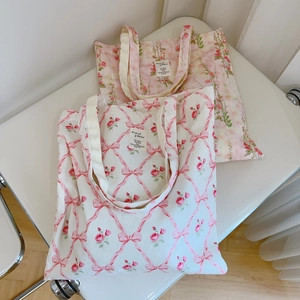 Flat lay detail of floral cotton tote bags with pink bow and rose prints for students