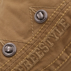 Detail der khakifarbenen Schirmmütze mit Freestyle-Stickerei und modischen Metallknöpfen