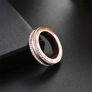 Detalle macro de un anillo de acero de titanio oro rosa con números romanos y piedras