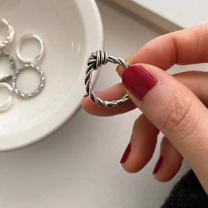 Macro detail of 925 sterling silver knotted ring set with retro distressed finish texture