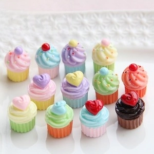 Detailed view of 12 colorful resin miniature cupcakes with various heart and cream toppings