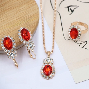 Macro view of bridal jewelry set with red oval gemstones and diamond halo accents