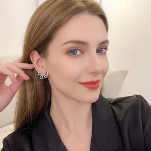 Elegant s925 silver black bow earrings with rhinestones shown on model for size and style