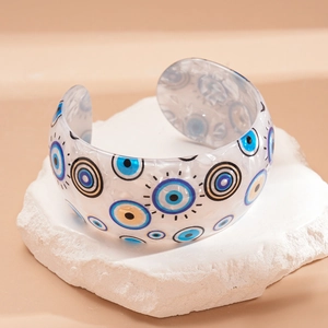 Macro detail of acrylic evil eye cuff bracelet with iridescent texture on stone base