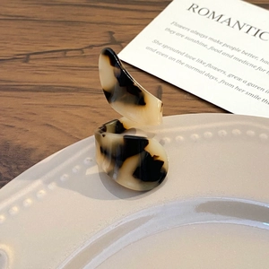 Macro detail of tortoiseshell resin ring with geometric pattern on a ceramic plate