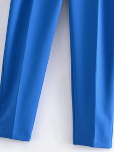 Detalle del pliegue central vertical y la textura de la tela azul del pantalón de vestir