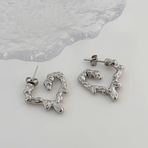 Macro shot of silver lava texture heart stud earrings with liquid metal aesthetic design