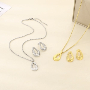 Detailed view of hollow teardrop pendants and twist chain necklaces in gold and silver