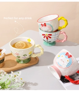 Detail of hand-painted ceramic mug with embossed rabbit and colorful woven handle