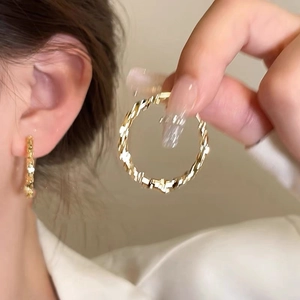 Boucles d'oreilles créoles dorées avec texture torsadée pour femmes de style minimaliste