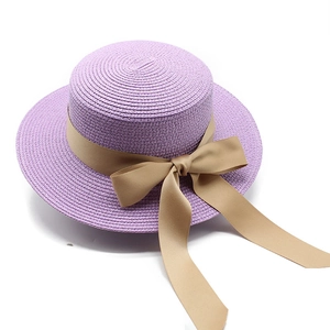 Dettaglio cappello di paglia lavanda a cima piatta con nastro champagne e fiocco