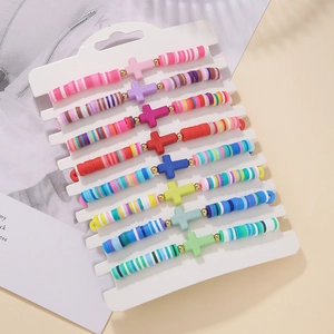Detail of 9 colorful bohemian polymer clay cross stretch bracelets in a set on minimalist background