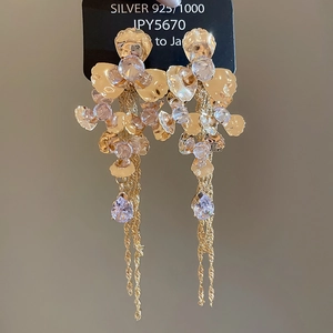 Detail of luxury 925 silver floral earrings with purple zircon tassels and gold plating