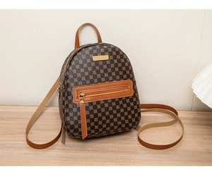 Detailed view of women's vintage floral pattern backpack in dark brown PU leather on a wooden desk
