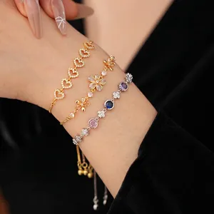 Ensemble de trois bracelets avec fleurs en zircon et pendentifs cœur sur le poignet
