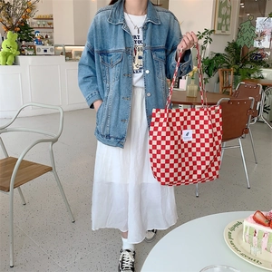 Red checkered canvas tote bag styled with denim jacket in a cozy cafe setting