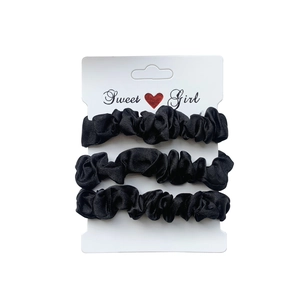 Three-piece set of black satin scrunchies displayed on a Sweet Girl card packaging