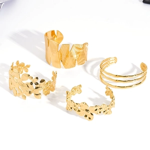 Set of four gold stainless steel cuffs featuring leaf texture and floral cut-outs