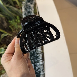Detail of a black glossy hair claw clip for elegant French style hairstyles and buns