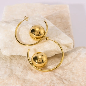 Polished gold hollow C-shaped earrings with sphere design on white stone props